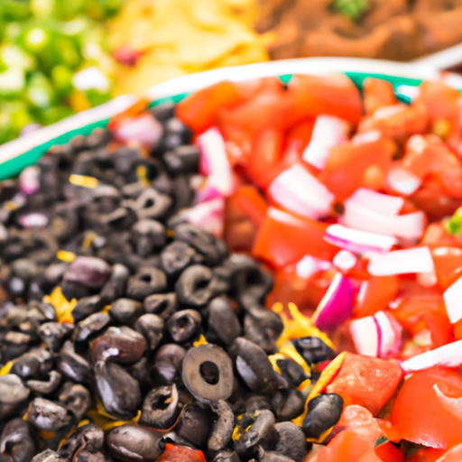 Assortment of colorful nacho toppings including black beans, tomatoes, and onions.